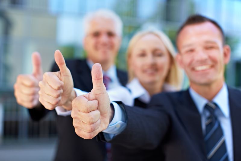 Business people giving a thumbs up